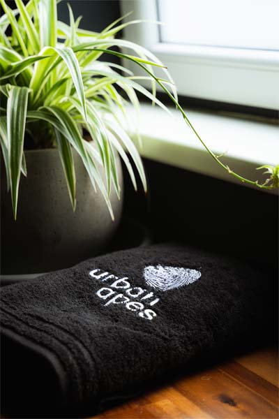 Grüne Pflanze und schwarzes Handtuch mit urban apes Logo