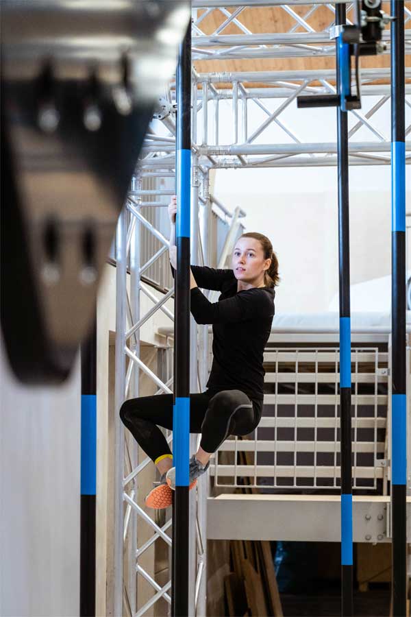 urban apes Hamburg West Frau an einer Stange im Ninja Parkour