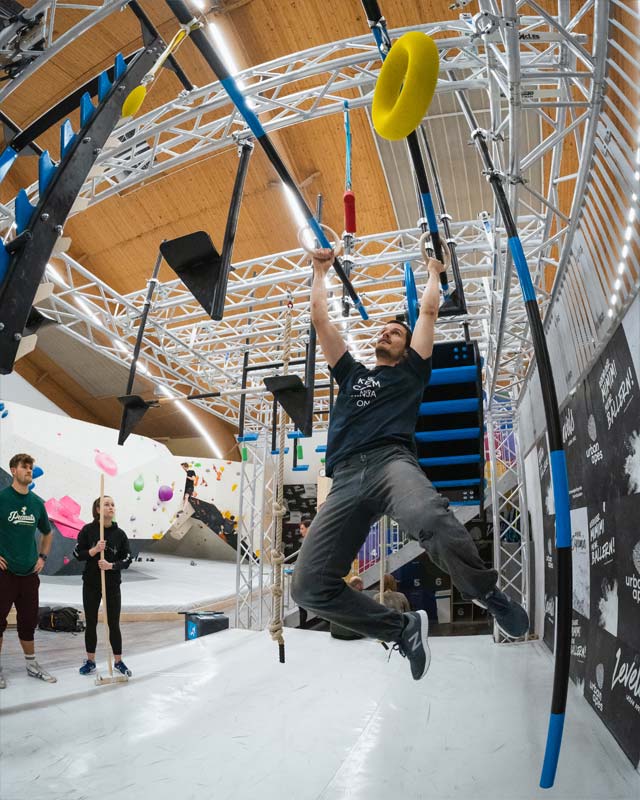 Mann schwingt sich am Ninja Parkour in urban apes Hamburg West nach vorne.