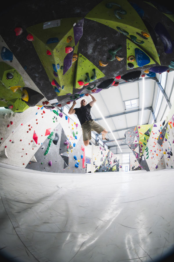 Boulderer beim Sprung am Überhang in der Boulderhalle von urban apes Lübeck