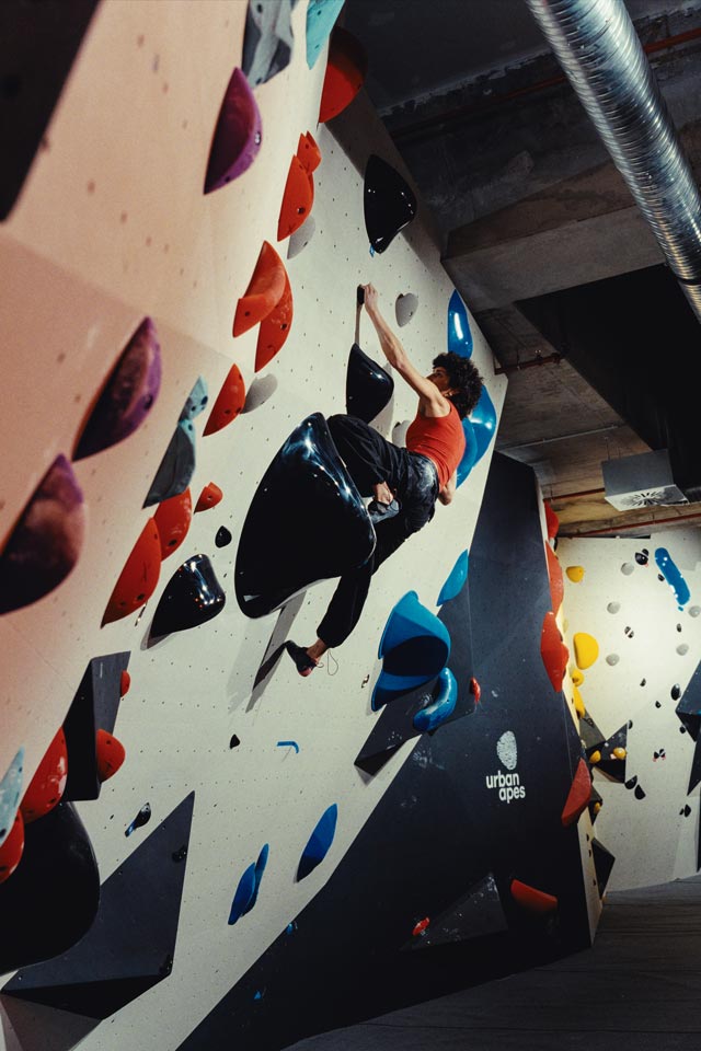 Boulderin an der Boulderwand im urban apes Fhain Berlin.